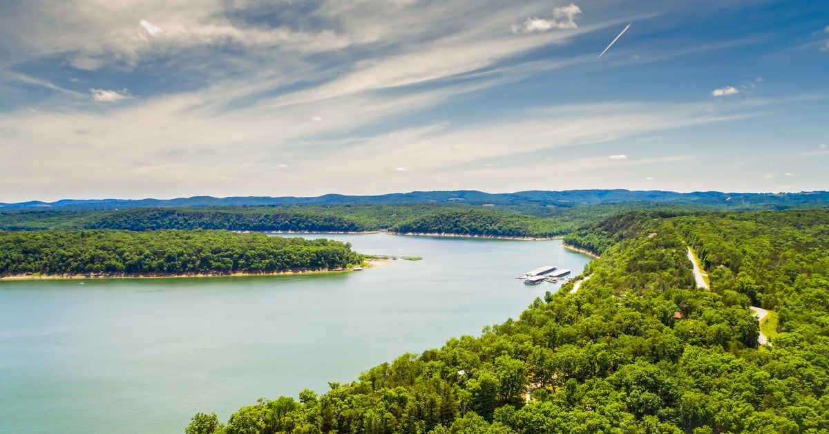 An aerial view of Bull Shoals Lake in Missouri. The lake has large, bright green forests on either side of it.