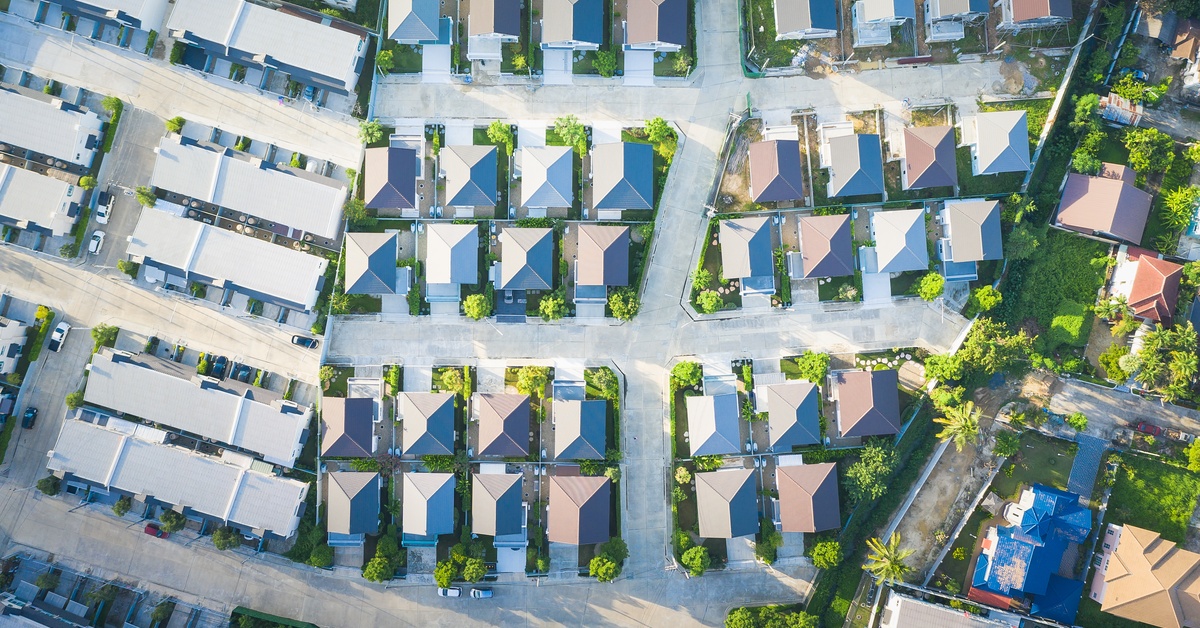 A top-down view of a series of houses. Each house is roughly the same size and has greenery in their yards.