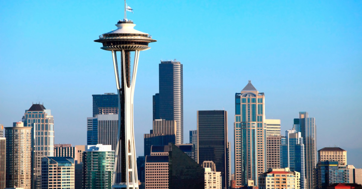The skyline of Seattle, Washington at sunset. The Space Needle takes up most of the skyline in front of the other buildings.