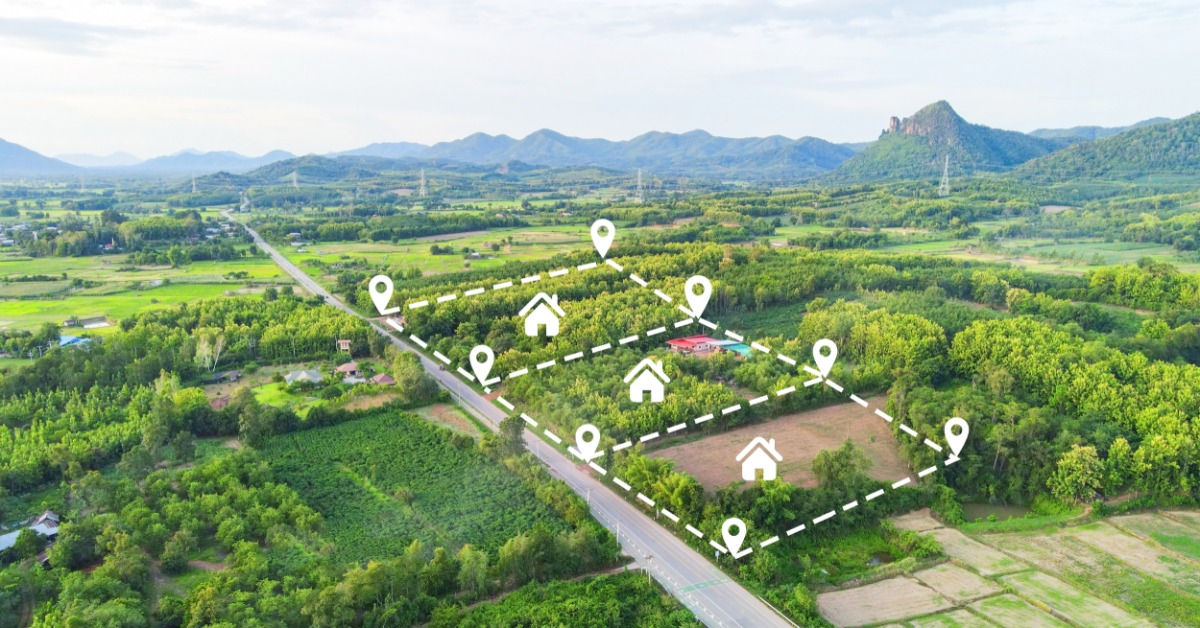 An aerial shot of three plots of land in a forested area. The land plots are outlined by GPS markers and dotted lines.